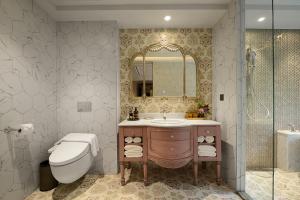 a bathroom with a sink and a toilet and a mirror at 格拉斯行館 Grasse Grace Manor in Nanzhuang