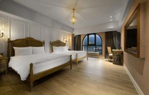 a bedroom with two beds and a large window at 格拉斯行館 Grasse Grace Manor in Nanzhuang