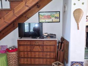 een woonkamer met een televisie op een houten dressoir bij Holiday home dei Pavoni, Montemaggiore in Montemaggiore al Metauro