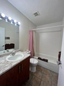 a bathroom with a sink and a toilet and a tub at Redford Motel in Port Alberni