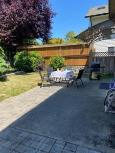 a patio with a table and chairs in a yard at Esquimalt Lagoon Life in Victoria
