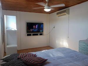 1 dormitorio con 1 cama y TV en la pared en En lo de su en Calchaquí