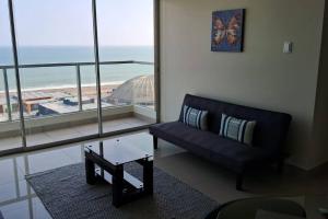 a living room with a couch and a view of the ocean at apartamento de estreno con balcón frente al mar. in Lima