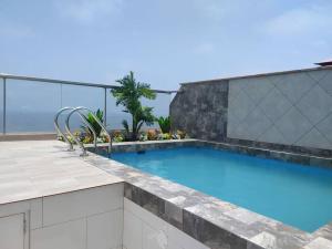 una piscina en la parte superior de un edificio en apartamento de estreno con balcón frente al mar. en Lima