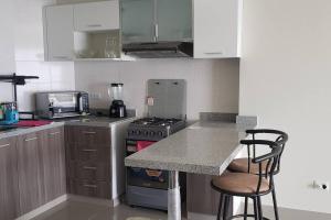 cocina con encimera y fogones horno superior en apartamento de estreno con balcón frente al mar. en Lima