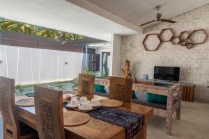 a dining room with a table and chairs and a television at Gili Khayangan Villas in Gili Trawangan