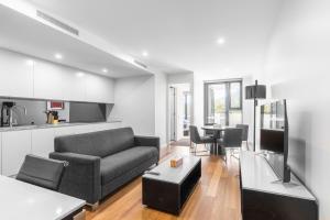 キャンベラにあるSerain Residences Next to Canberra Centreのリビングルーム(ソファ、テーブル付)