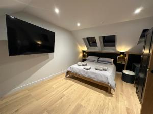 a bedroom with a bed and a large tv at Laurieston Penthouse 