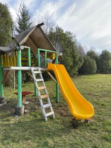 un parque infantil con un tobogán amarillo y una escalera en Cabañas Campestres Villarrica, en Villarrica