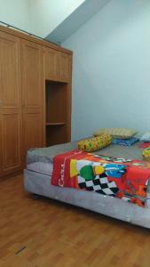 Un dormitorio con una cama con una manta de colores. en Villa Bukit Asri Untuk 1 Kamar Berastagi View, en Berastagi
