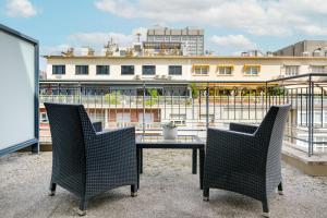 einen Tisch und Stühle auf einem Balkon mit einem Gebäude in der Unterkunft AC Hotel Aitana by Marriott in Madrid