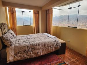 a bedroom with a bed and a large window at Casa Mirador SanBlas in Cusco