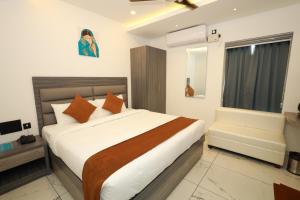 sypialnia z dużym łóżkiem i krzesłem w obiekcie Goodland Elegance w mieście Thiruvananthapuram