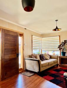 a living room with a couch in front of a window at Mehuín el Remanso de Paz in Mehuín