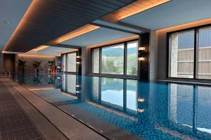 a swimming pool in a building with windows at Courtyard by Marriott Chongli in Zhangjiakou