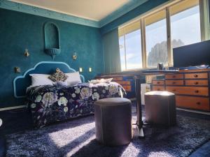 a bedroom with a bed and a dresser and windows at Pure Motel in Rotorua