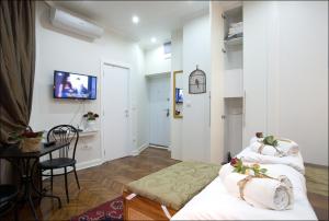 Habitación con 2 camas, mesa y TV. en Belle Apartments - Square 8, en Belgrado