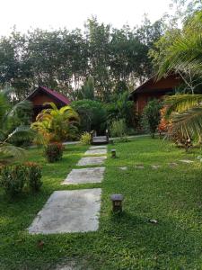 a garden with a walkway in the grass at Najjamee Bungalows in Ko Yao Noi