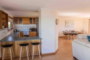 een keuken en een woonkamer met een bank en een tafel bij Home @ Scamander Beach in Scamander