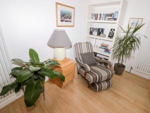 a living room with a chair and a lamp at The Gallery in Tenby