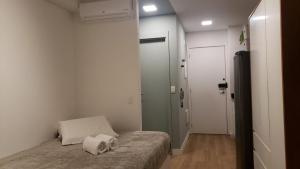 um pequeno quarto com uma cama com duas toalhas em Studio Ben em São Paulo