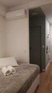 Un dormitorio con una cama con una toalla. en Studio Ben en São Paulo