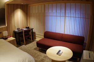 a room with a couch and a table and a desk at Kasuga Hotel in Nara