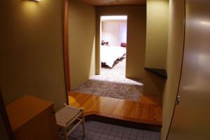 a hallway with a room with a bed and a chair at Kasuga Hotel in Nara