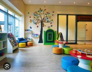 uma área de recreação infantil com um mural de árvore numa loja em Uptown Parksuites BGC em Manila