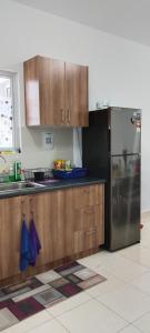 cocina con armarios de madera y nevera de acero inoxidable en MQA Homestay en Sepang