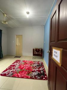a room with a large red rug on the floor at Hidayah Homestay Tawau in Kampong Parit