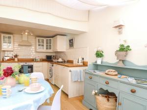 a kitchen with a table with a blue counter top at Bridge Cottage in Norwich