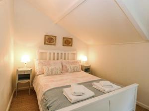 諾里奇的住宿－Bridge Cottage，一间卧室配有一张床,上面有两条毛巾