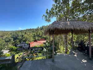 a sign for a hotel with a straw umbrella at Munduk Tutub waterfall view in Munduk