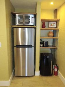 eine Küche mit einem Kühlschrank und einer Mikrowelle darüber in der Unterkunft Hale Laule'a at Opihi Point - Oceanfront, Gated Estate in Hakalau
