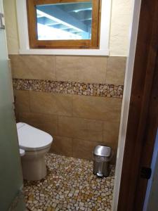 ein Bad mit einem WC und einem Fenster in der Unterkunft Hale Laule'a at Opihi Point - Oceanfront, Gated Estate in Hakalau
