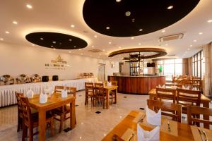 マンダレーにあるHavana Hotel Mandalayの木製テーブルと木製椅子のあるレストラン