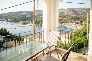 een balkon met een tafel en stoelen en uitzicht op het water bij sivotahomes-Amaya in Sivota