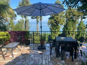 a patio with a table and chairs and an umbrella at Feride in Makhinjauri