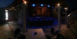 a patio with a table and chairs at night at Athina Studios in Argasi