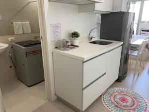 a small kitchen with a sink and a refrigerator at Dtravellers Home 1 at AZURE NORTH BALI Tower in San Fernando