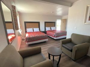 um quarto de hotel com duas camas e um sofá em Palm Inn em Mojave