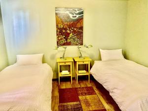 a room with two beds and a table with a painting at The Finca - Moab's Hidden Gem in Moab
