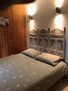 a bed with two pillows on it in a room at Chalet dans plusieurs hectares de nature in Barjols