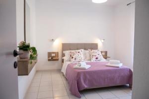 a bedroom with a purple bed with two towels on it at sivotahomes-Amaya in Sivota