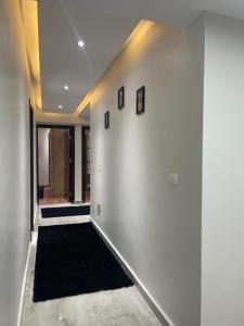 a hallway with a white wall with a black rug at شقق سكنيه رائعه الجمال تطل علي النيل in Cairo