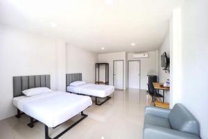 a hotel room with two beds and a couch at Gasira Green in Ban Tha Kham