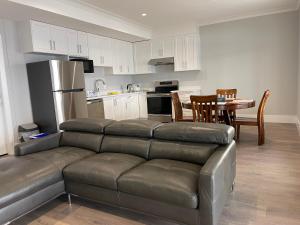 Il comprend un salon avec un canapé en cuir et une cuisine. dans l'établissement Auspicious Sea View House, à Nanaimo