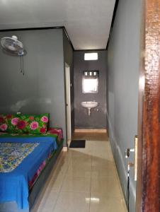 a bathroom with a bed and a sink in a room at T&T Homestay in Kuta Lombok