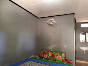a room with a bed with a sink and flowers at T&T Homestay in Kuta Lombok
